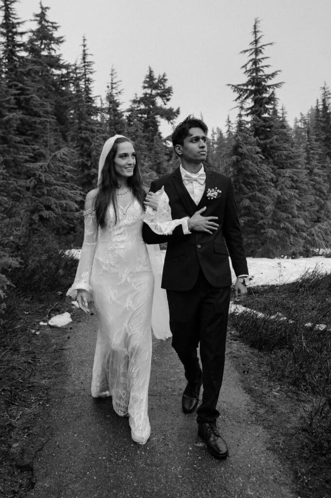 Couple walking together during a moody Artist Point elopement surrounded by evergreen trees in the North Cascades.