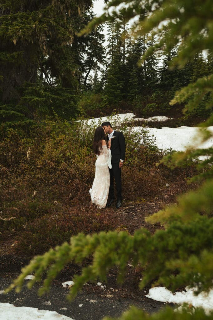Intimate forest elopement moment at Artist Point with evergreen trees and early spring snow.