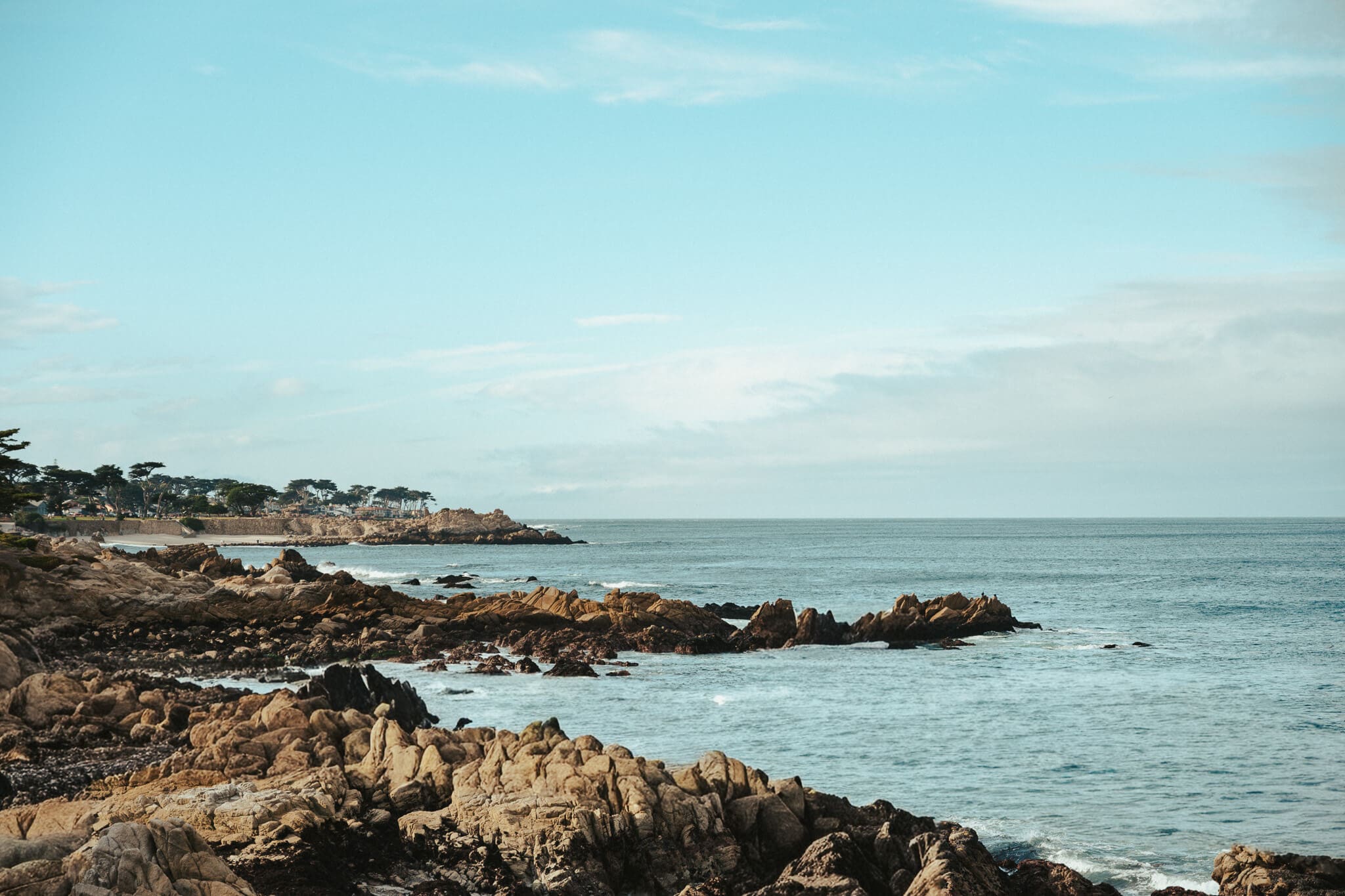 Rugged coastal scenery along the Pacific Grove shoreline, featuring rocky outcrops and calm ocean views on California’s Monterey Peninsula.
