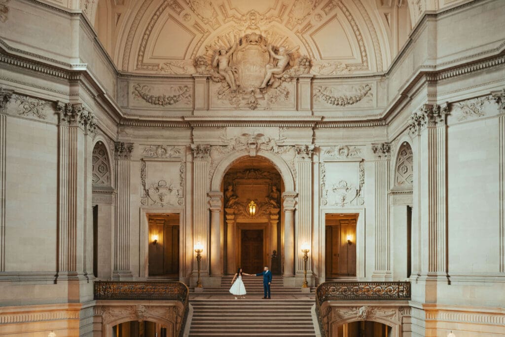 Romantic elopement kiss on the grand staircase inside San Francisco City Hall