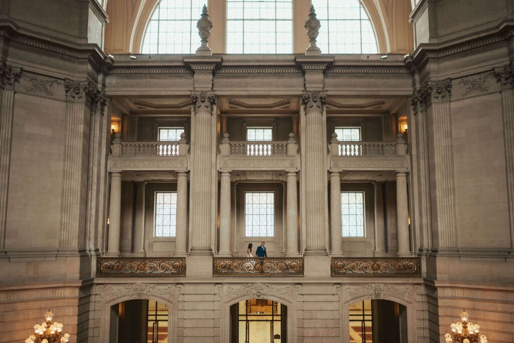 Romantic portrait of an eloping couple holding hands on the San Francisco City Hall staircase