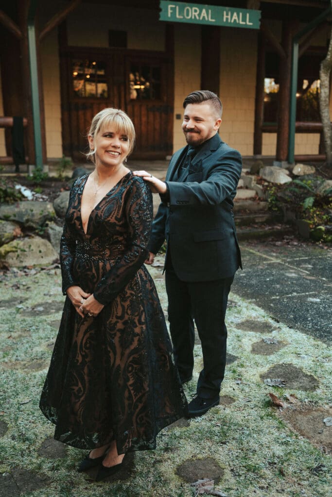 Mother of the Groom and the Groom sharing a first look outside the Floral Hall venue sign in Everett, WA.