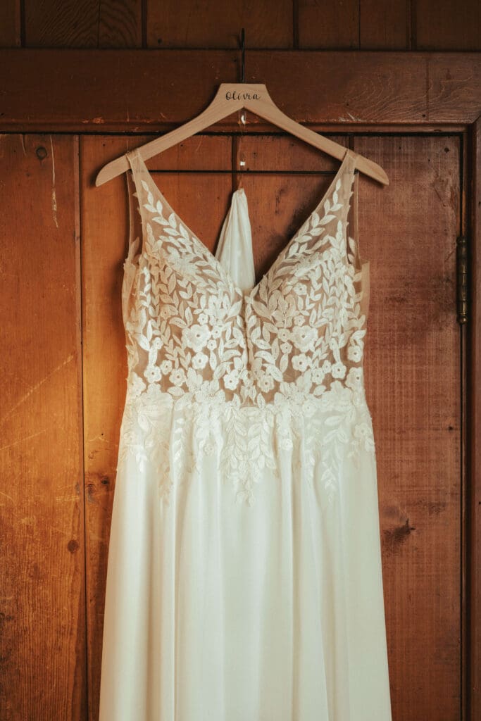 Lace wedding dress hanging on a personalized hanger during getting ready at Floral Hall in Everett, WA.