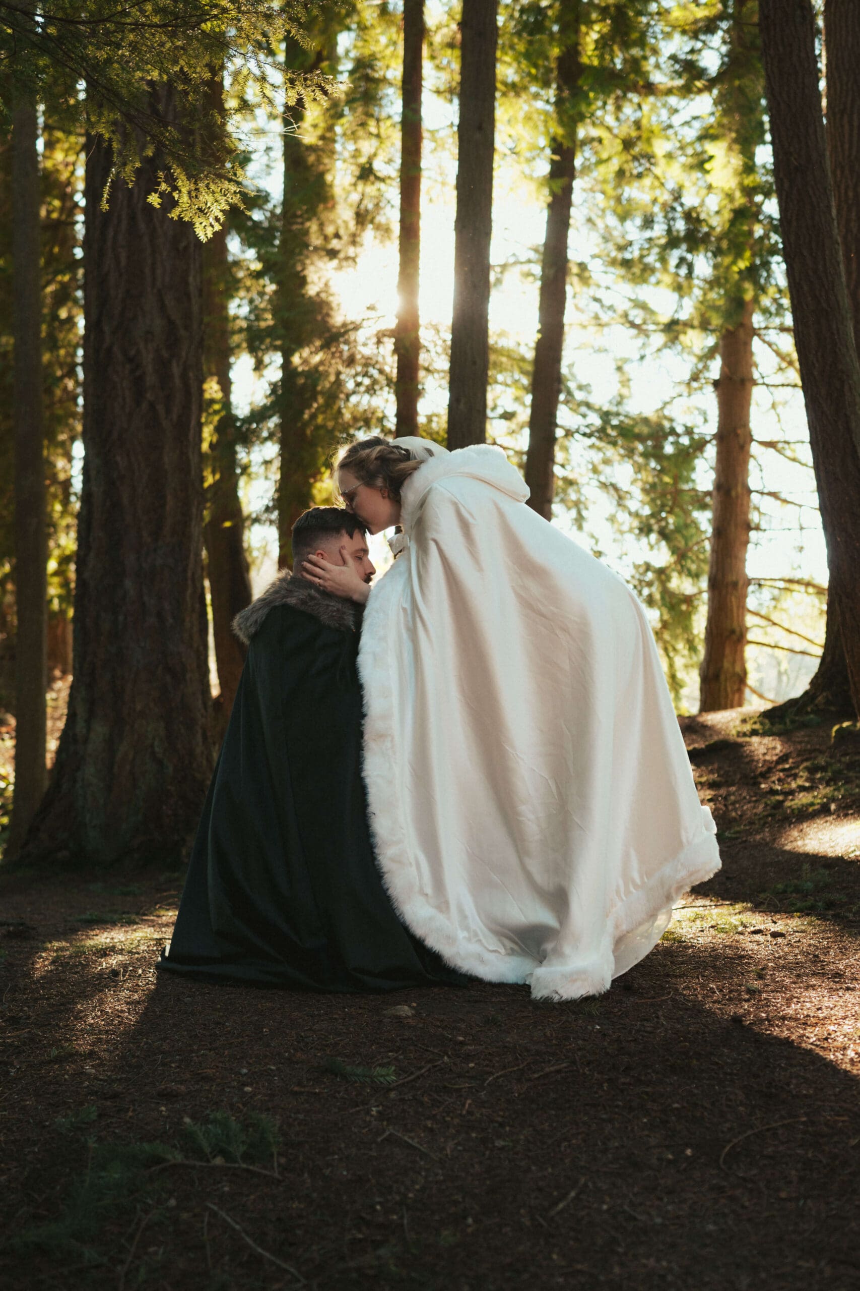 Romantic forest portrait of the couple wrapped in winter capes near Floral Hall in Everett, WA.
